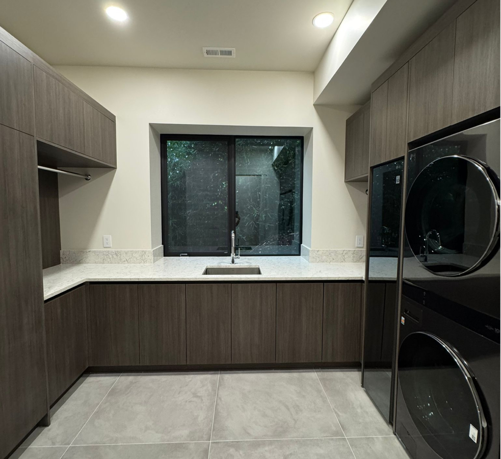 Built in laundry room cabinetry with dark wood finish