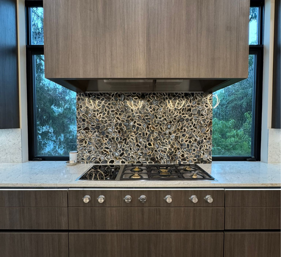 Cooktop area with textured backsplash and custom cabinets