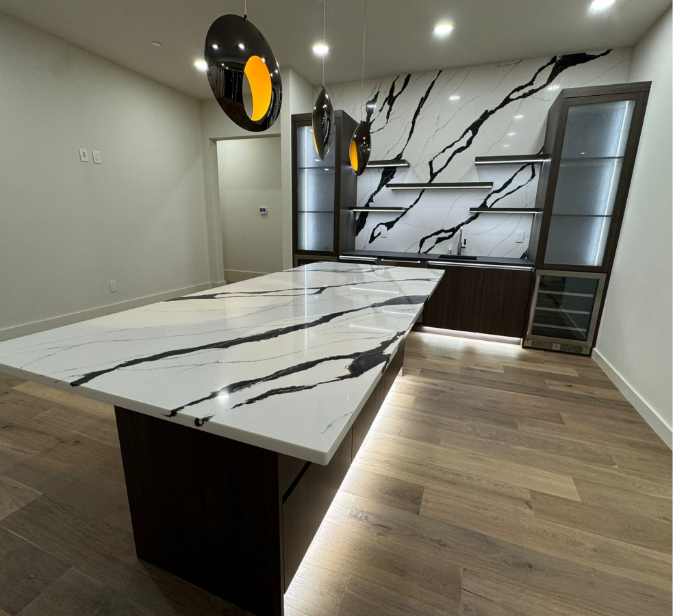 Long island with illuminated cabinetry and feature wall